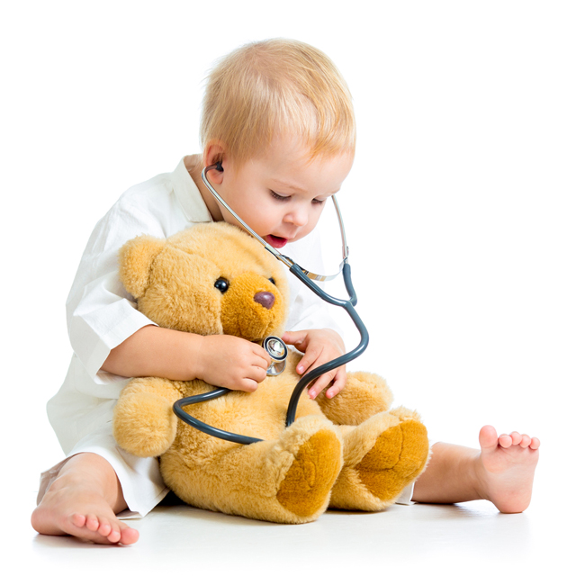 Baby giving teddy bear a checkup