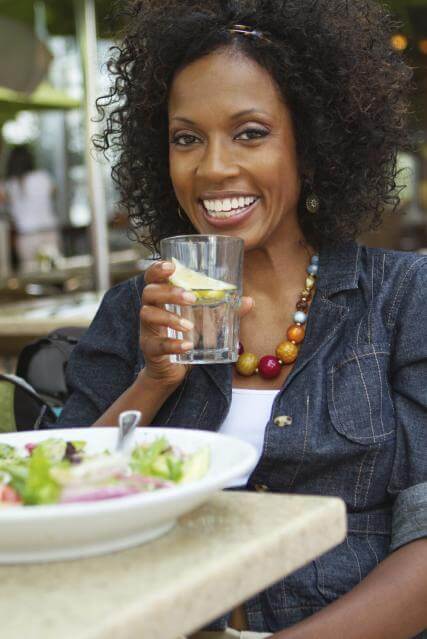 Lady smiling and drinking water