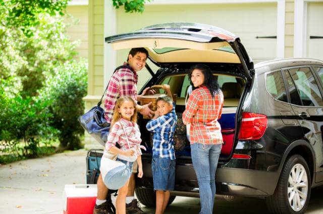 family packing a car for vacation