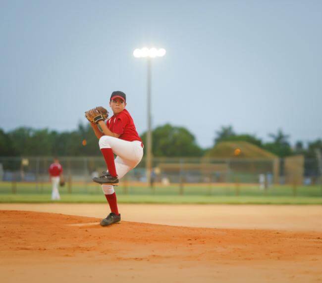 Boy pitching at a baseball game