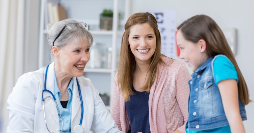 Pediatrician checks young girl's reflexes