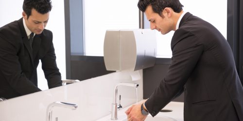 businessman washing his hands at restroom