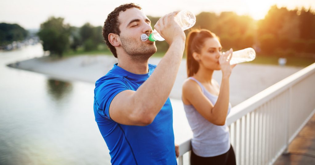 Picture of a couple staying hydrated after workout.