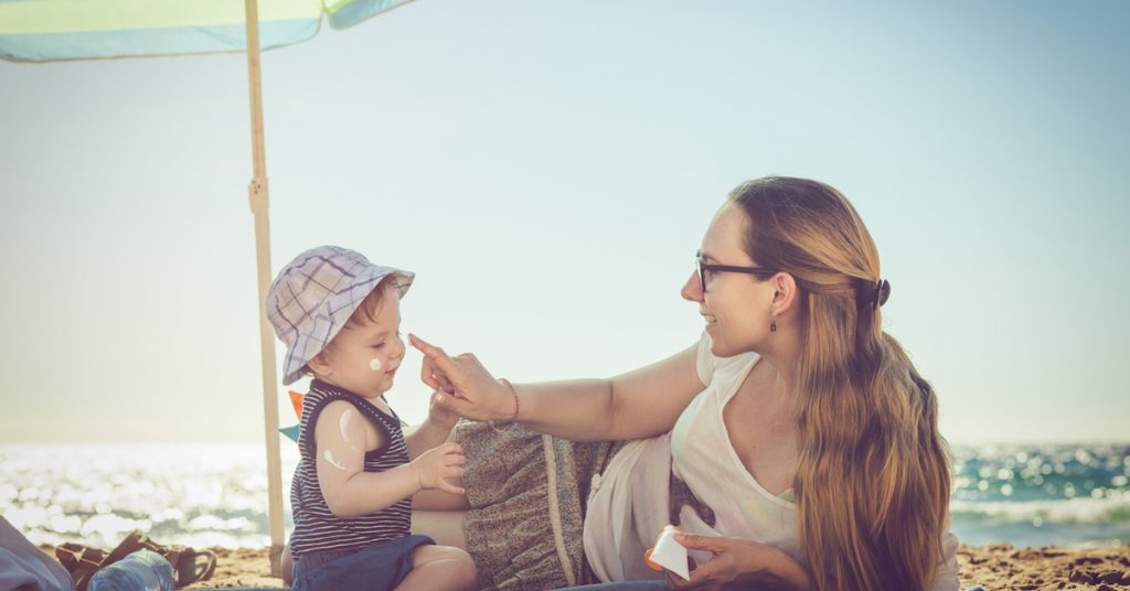 Picture of a mother applying sunblock on her baby.