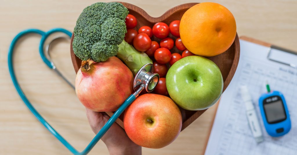 Picture of healthy food and a diabetic measuring tool kit on a table.