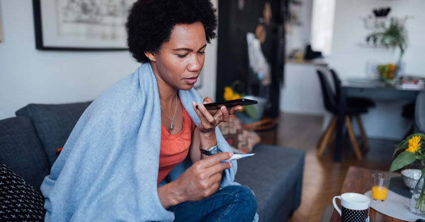 Woman on the phone covered in blanket