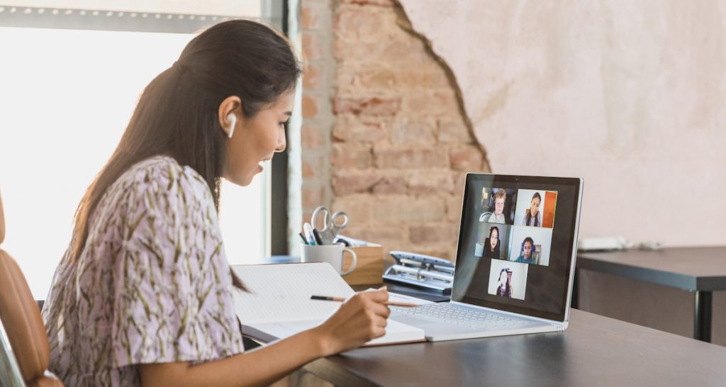 A woman working from home wearing earbuds