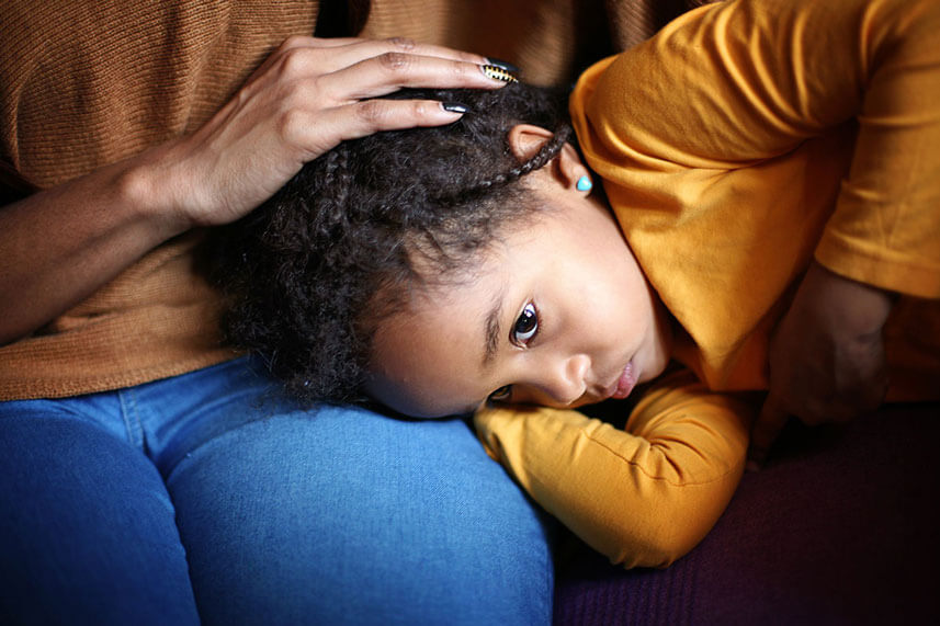 girl with head on moms lap